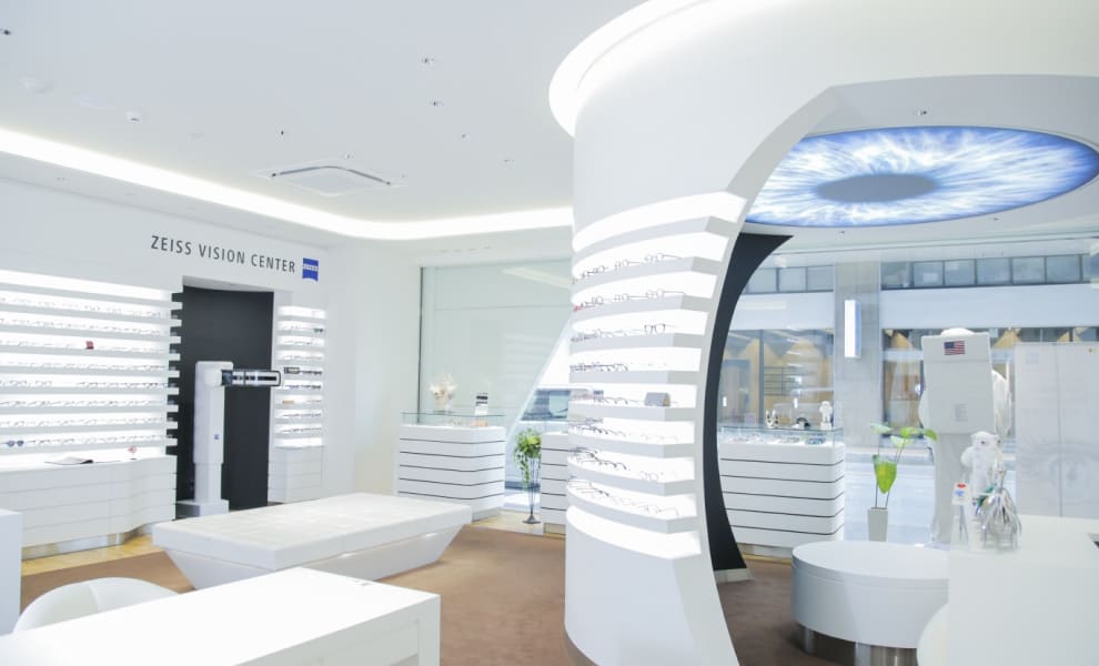 ZEISS VISION CENTERの店内写真：白を基調とした内観で、眼鏡や検査道具が置いてある。